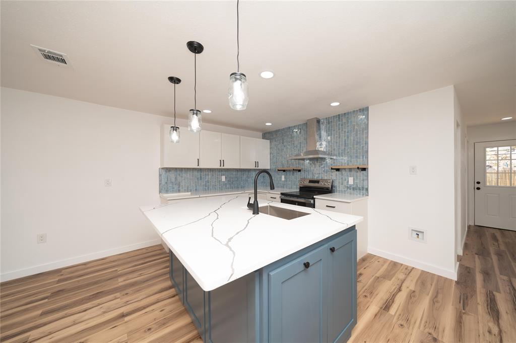 312 North Retta Street Fort Worth, TX 76111 - Photo 8 of 30 a kitchen with a sink a center island stainless steel appliances and cabinets