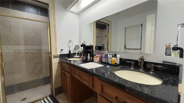 a bathroom with a granite countertop double vanity sink and a mirror