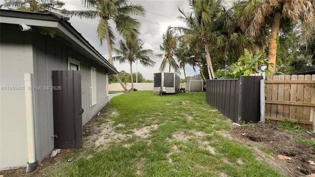 a view of a yard with wooden fence and a bench