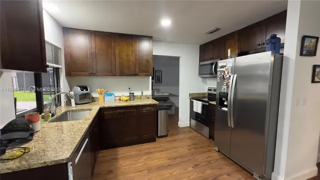 a kitchen with granite countertop stainless steel appliances and wooden cabinets