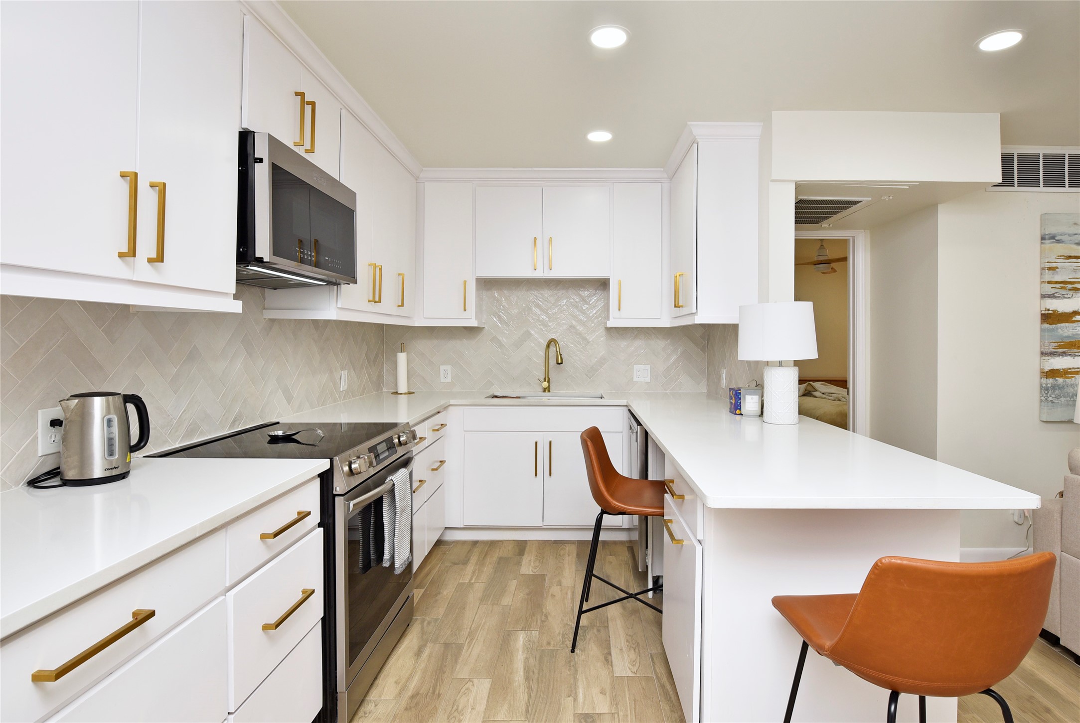 3224 Timmons Lane, Unit 112 Houston, TX 77027 - Photo 13 of 30 a kitchen with stainless steel appliances a stove a sink a microwave a refrigerator and cabinets