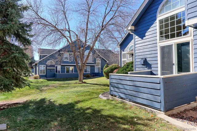 a front view of house with yard and trees in the background