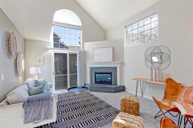 a living room with furniture a fireplace and a large window