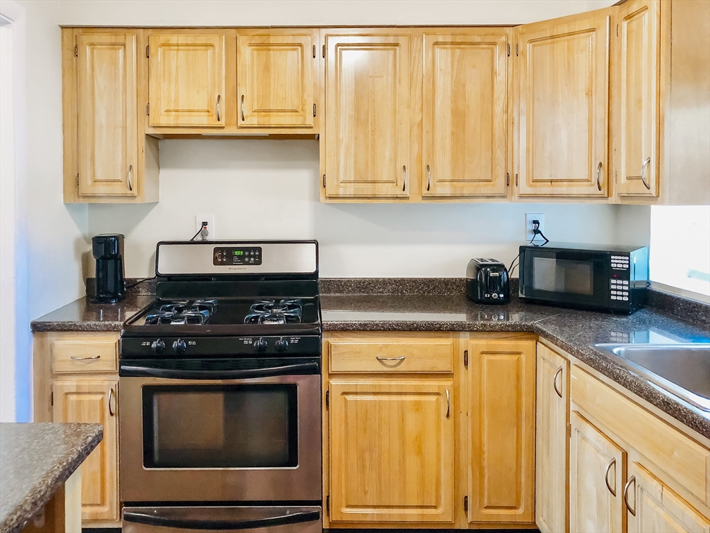 675 Chestnut Hill Avenue Brookline, MA 02445 - Photo 6 of 23 a kitchen with stainless steel appliances granite countertop white cabinets and a stove top oven
