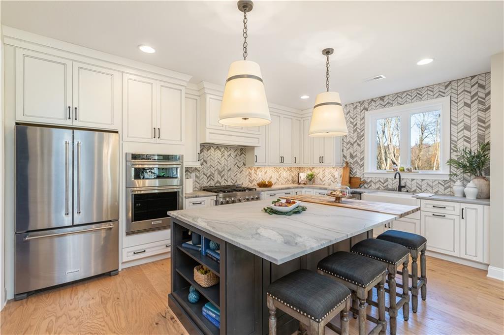 103 Maggie Drive Eighty Four, PA 15330 - Photo 7 of 23 a kitchen with granite countertop a table chairs stainless steel appliances and wooden floor