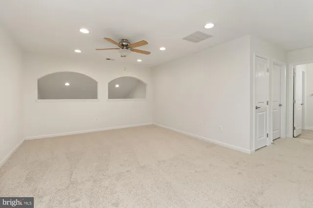 an empty room with a ceiling fan and a window