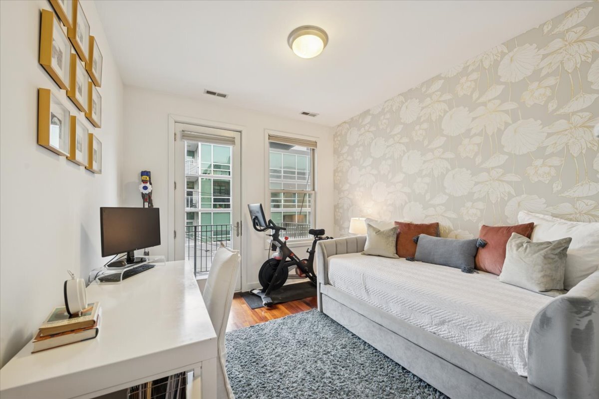 1234 North Milwaukee Avenue, Unit 3 Chicago, IL 60622 - Photo 13 of 16 a living room with furniture a flat screen tv and gym equipment