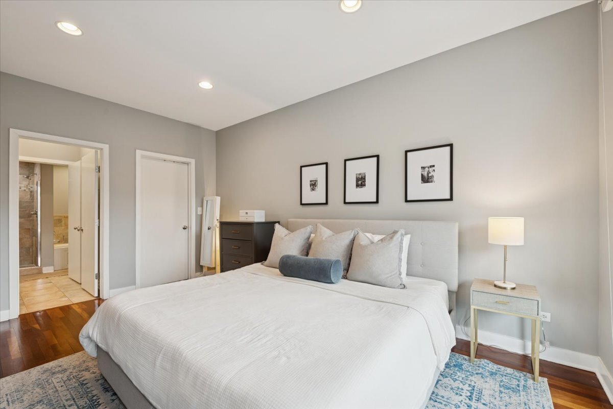 1234 North Milwaukee Avenue, Unit 3 Chicago, IL 60622 - Photo 10 of 16 a bedroom with a large bed and a lamp