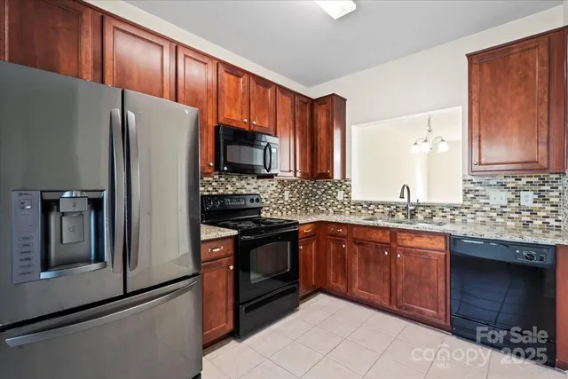 a kitchen with granite countertop a refrigerator stove and sink