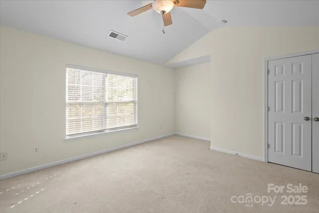 a view of an empty room with a ceiling fan