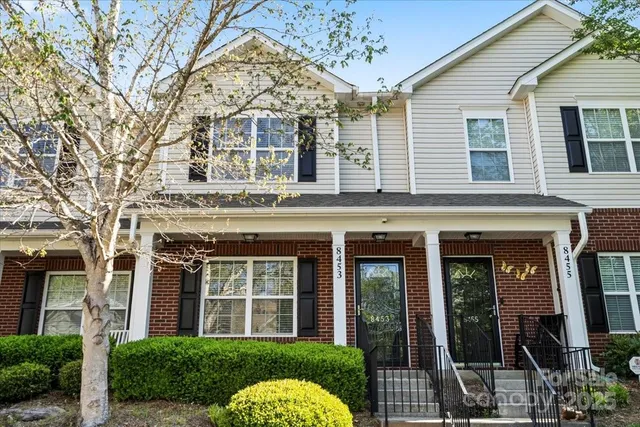a view of a house with a tree in front of it