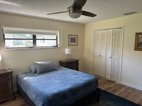 a living room with a couch wooden floor and a large window