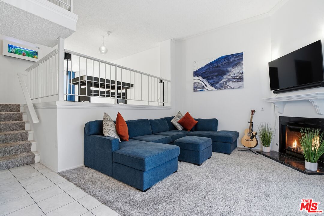 19355 Sherman Way, Unit 42 Reseda, CA 91335 - Photo 3 of 41 a living room with furniture a flat screen tv and a fireplace