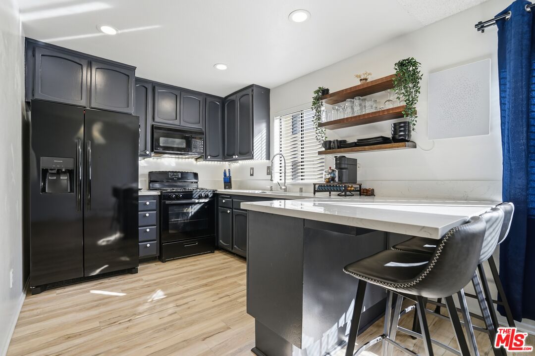 19355 Sherman Way, Unit 42 Reseda, CA 91335 - Photo 7 of 41 a kitchen with a sink refrigerator and cabinets