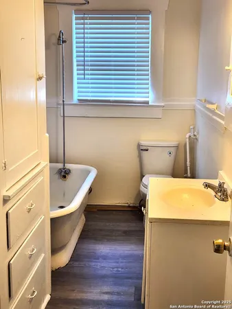 a bathroom with a tub sink and mirror