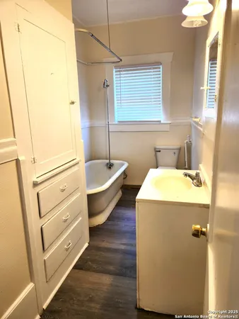 a bathroom with a tub sink toilet and mirror