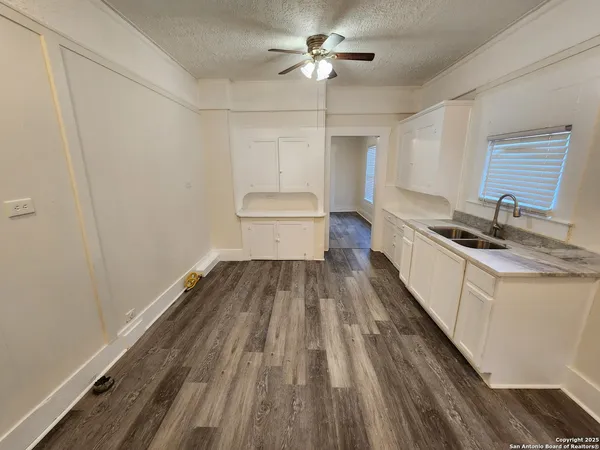 a kitchen with a sink and wooden floor