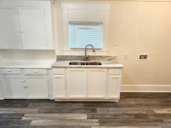 a view of a sink and dishwasher with wooden floor