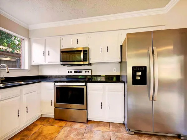 a kitchen with stainless steel appliances a refrigerator a stove a microwave and cabinets