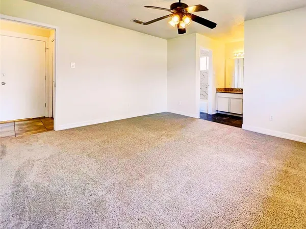 an empty room with a ceiling fan and a window