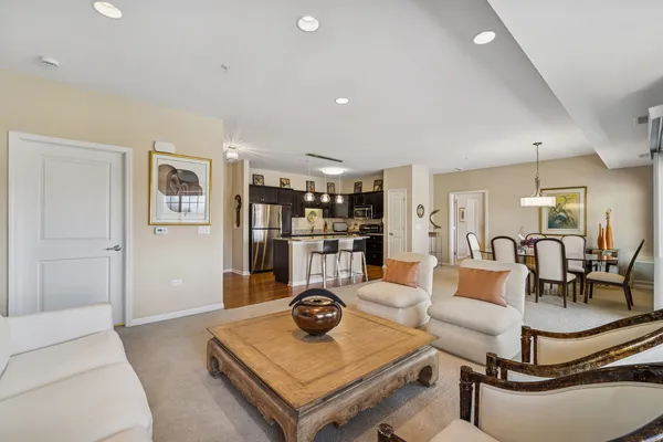 a living room with furniture and view of kitchen