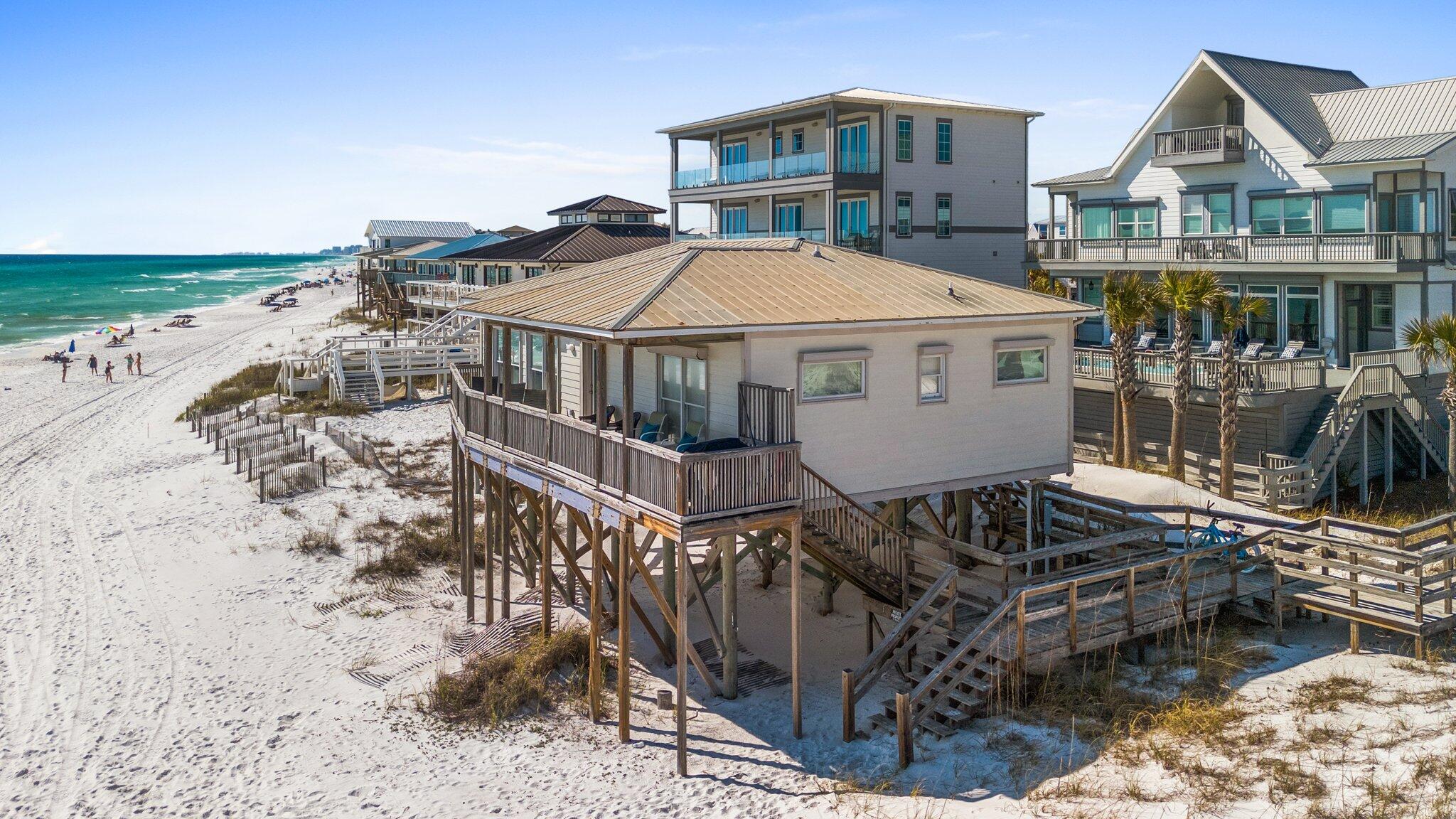 a view of a house with wooden deck and a barbeque