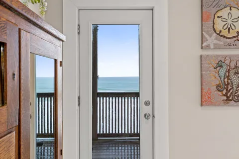 a view of a hallway with wooden floor and a door