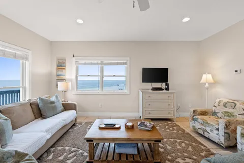 a living room with furniture a flat screen tv and a window