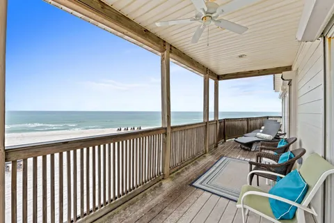 a balcony with wooden floor table and chairs