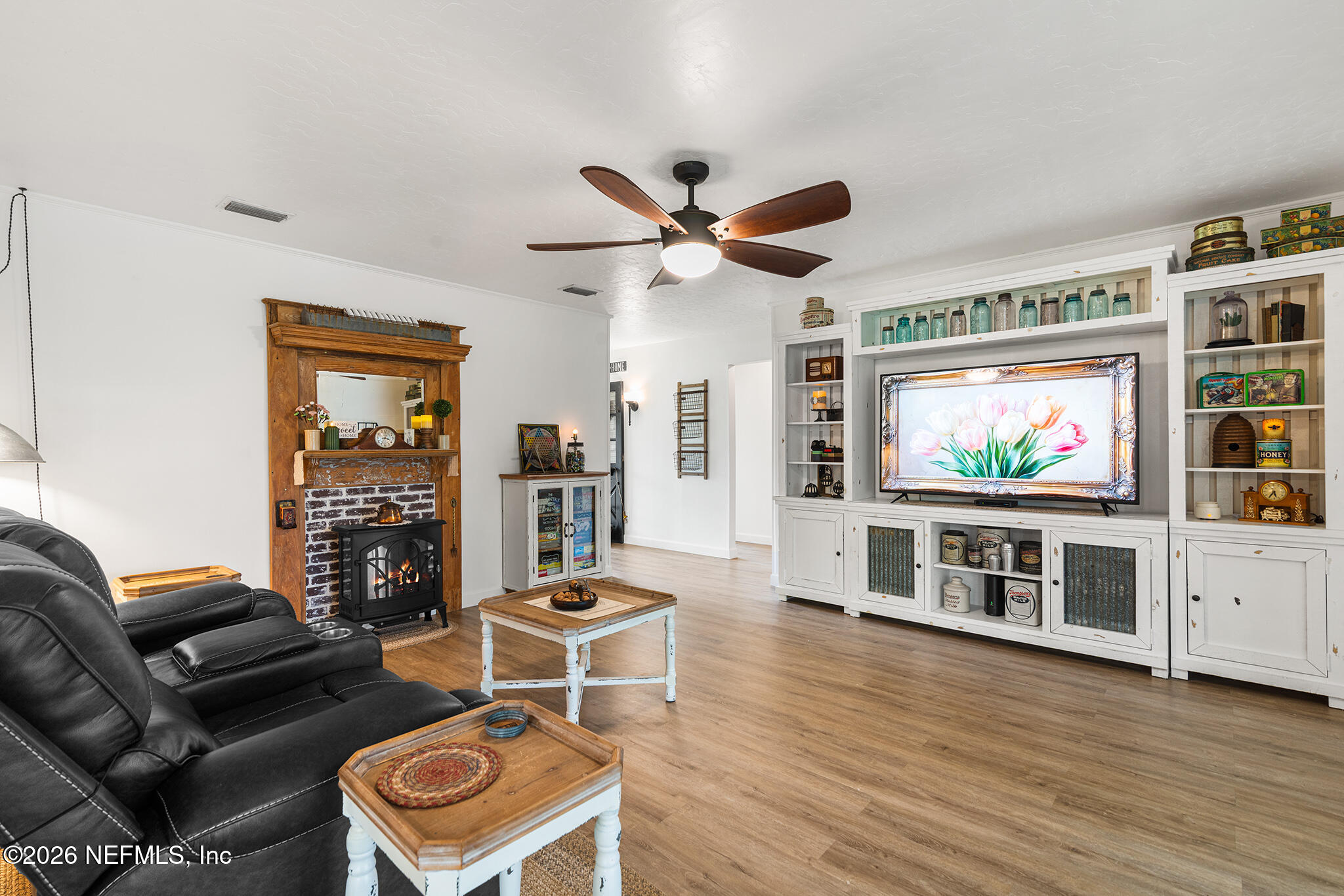 8208 Worm Wood Road Jacksonville, FL 32210 - Photo 10 of 35 a living room with furniture a flat screen tv and a fireplace