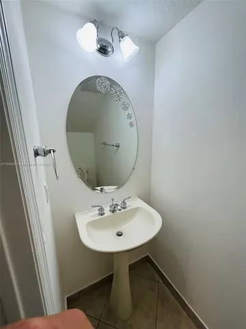 a bathroom with a sink mirror and toilet