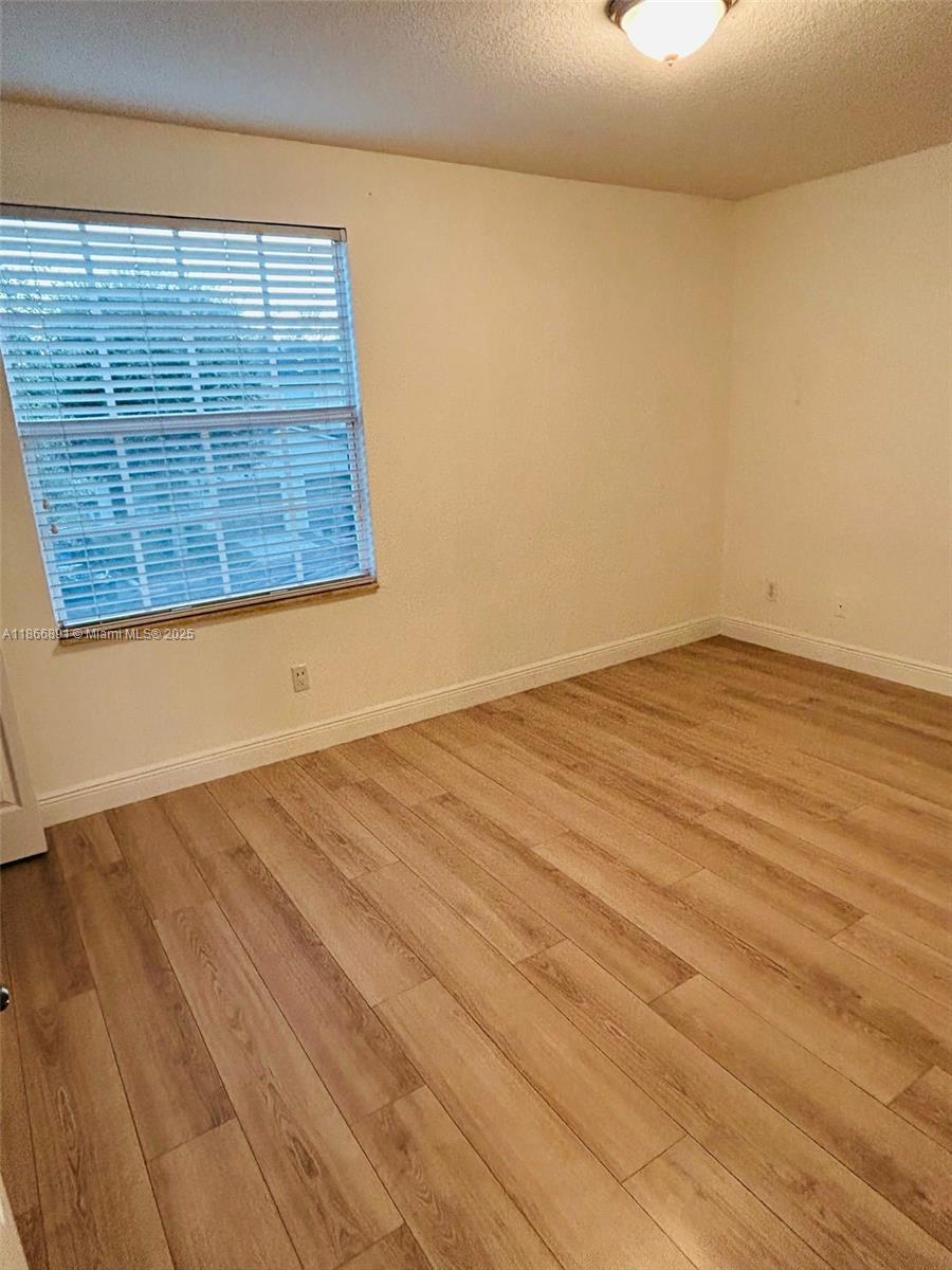 22129 Majestic Woods Way, Unit 504 Boca Raton, FL 33428 - Photo 15 of 23 a view of empty room with wooden floor and fan