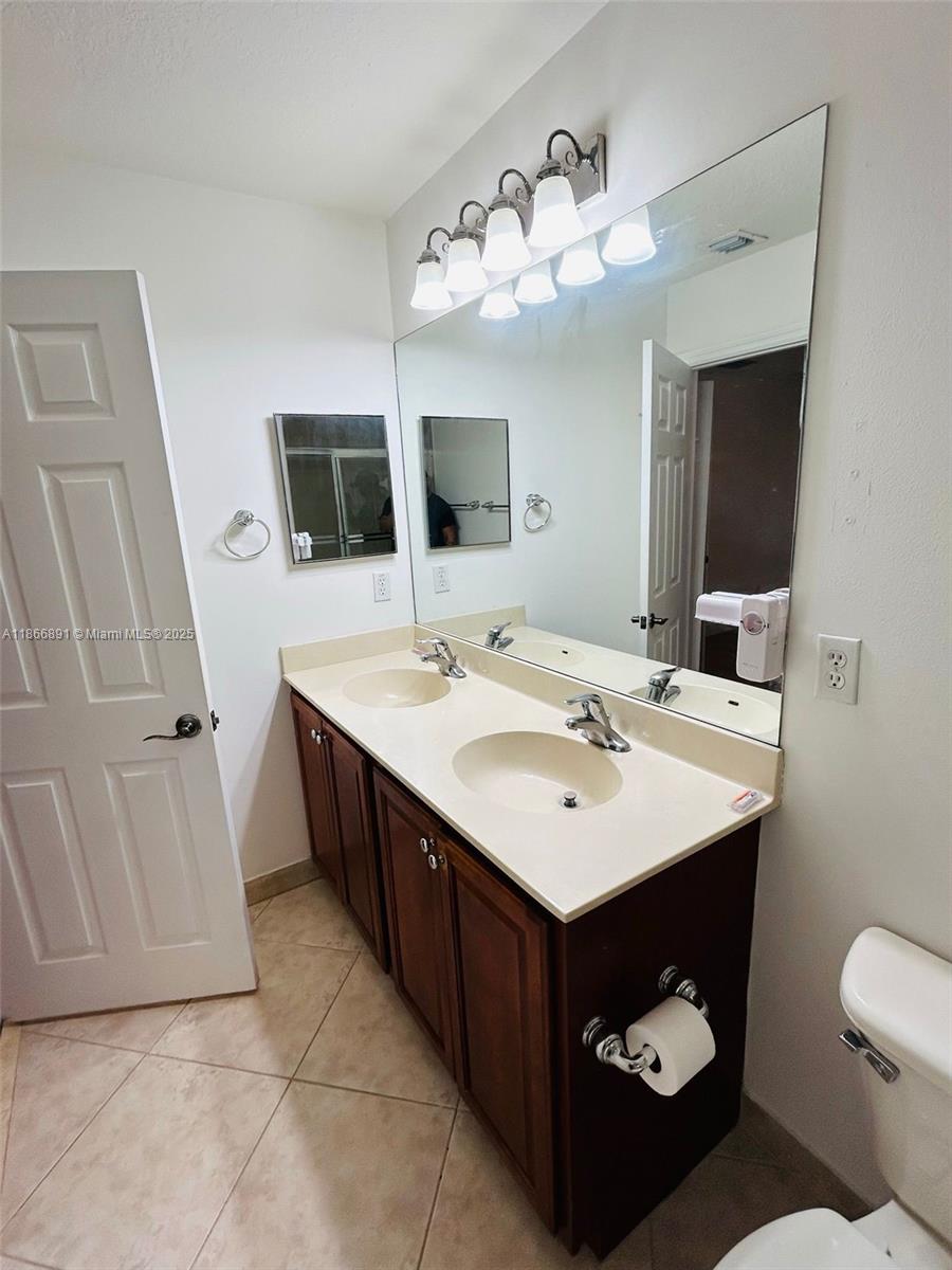 22129 Majestic Woods Way, Unit 504 Boca Raton, FL 33428 - Photo 23 of 23 a bathroom with a sink vanity and mirror