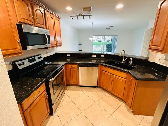 a kitchen with stainless steel appliances granite countertop a sink stove and microwave