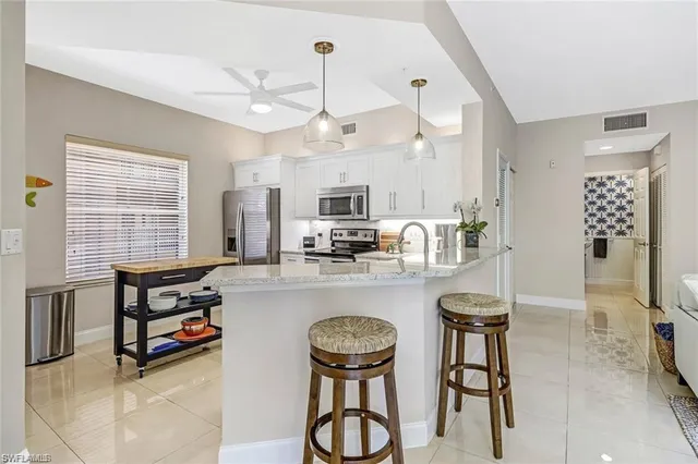 a kitchen with stainless steel appliances granite countertop a stove and white cabinets