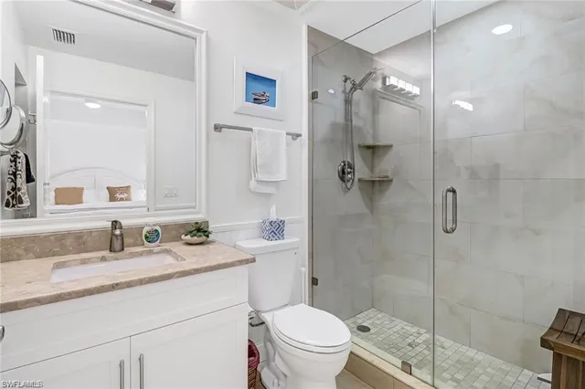 a bathroom with a shower sink mirror and toilet