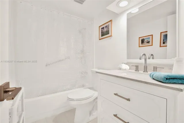 a bathroom with a granite countertop toilet and a sink