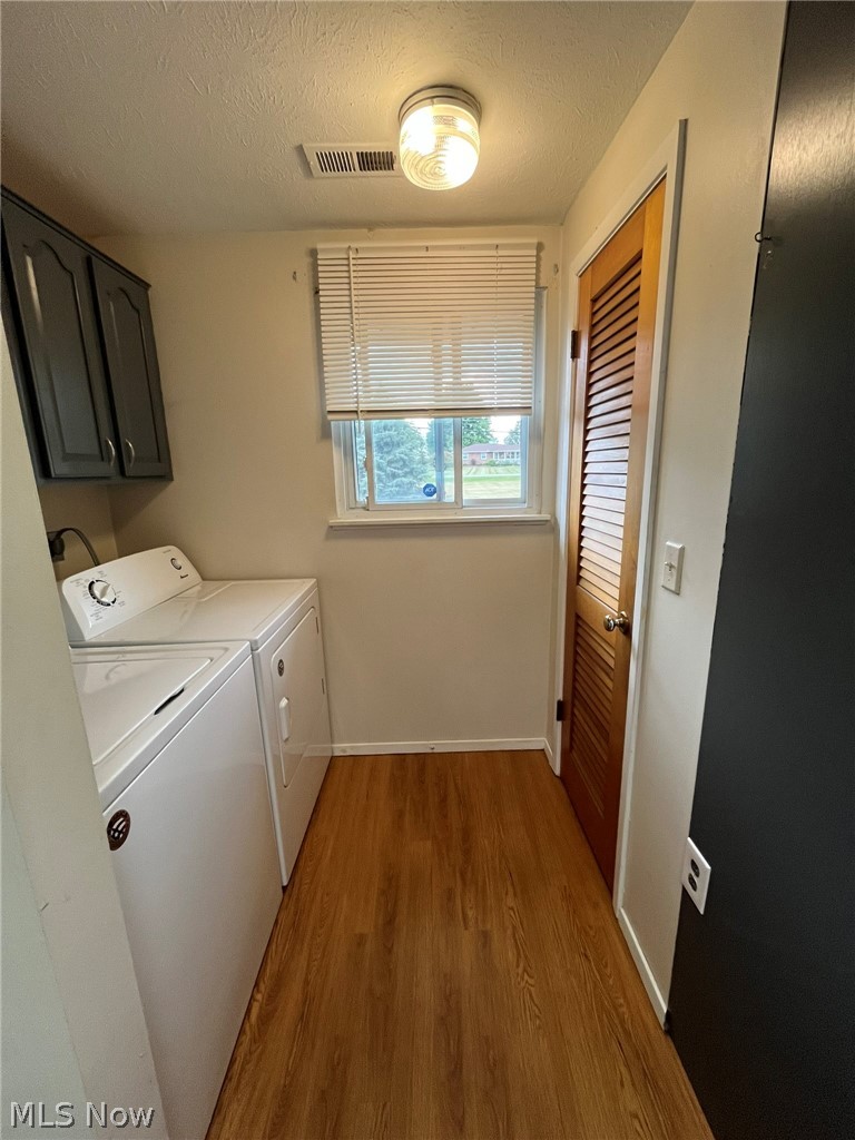 8945 West Ridge Road Elyria, OH 44035 - Photo 8 of 22 Clothes washing area featuring separate washer and dryer, hardwood / wood-style flooring, cabinets, and a textured ceiling