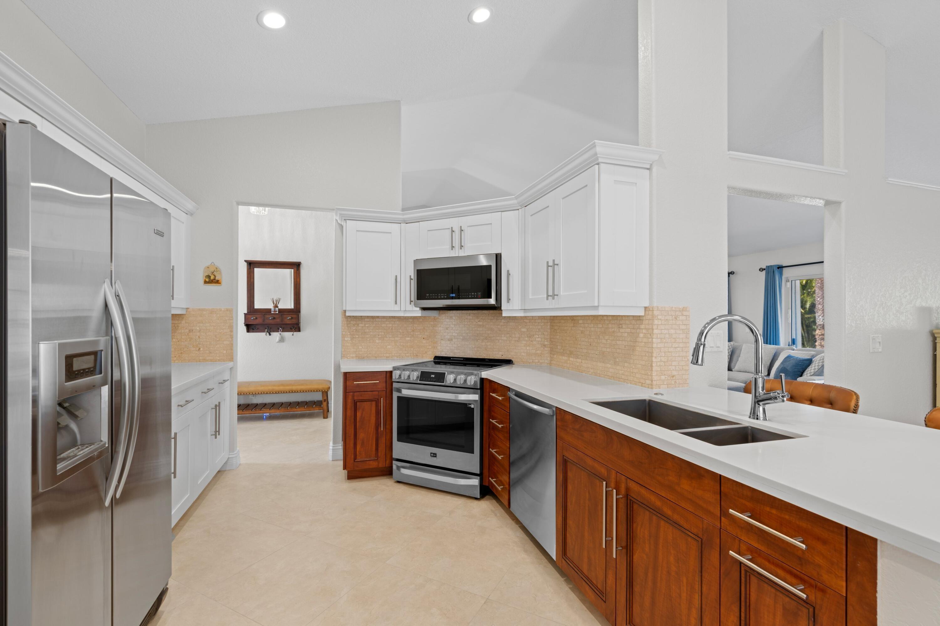 7598 Fairway Trail Boca Raton, FL 33487 - Photo 8 of 50 a kitchen with stainless steel appliances a refrigerator a sink a stove and cabinets