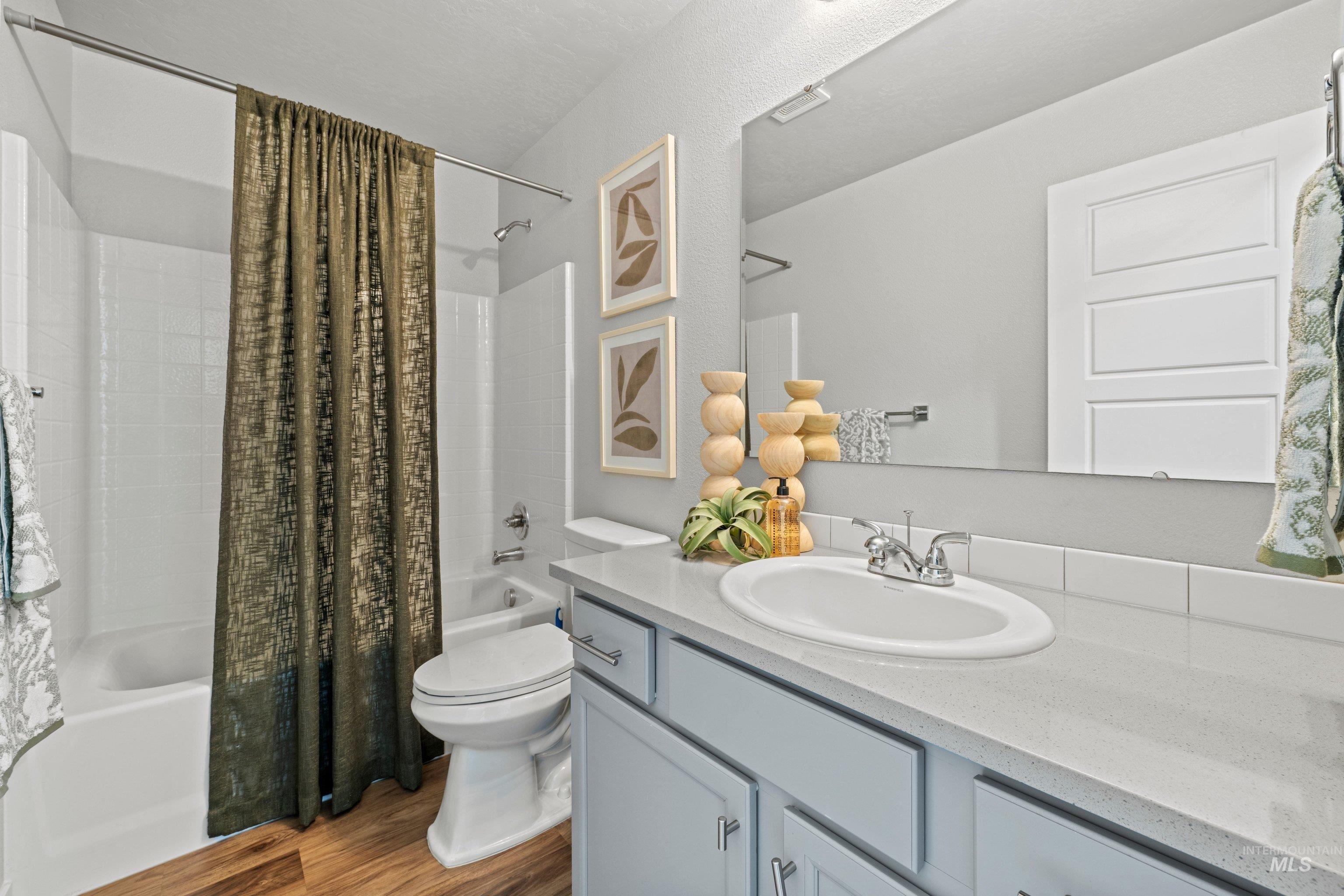 12744 West Fig Street Boise, ID 83713 - Photo 22 of 34 Bathroom vanity featuring an integrated sink, light-toned countertop, and light blue cabinetry with brushed nickel hardware