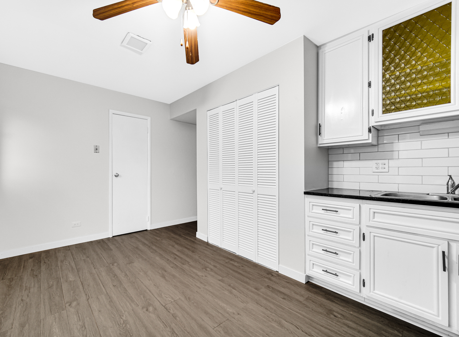 1765 Short Avenue Streamwood, IL 60107 - Photo 5 of 18 an empty room with cabinet wooden floors and white walls