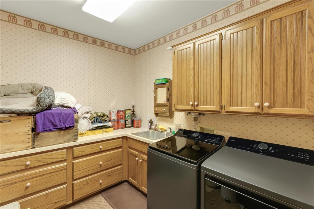 2717 Clear Lake Road Weatherford, TX 76087 - Photo 25 of 40 Utility room featuring extensive wood cabinetry, a built-in sink with a countertop, and a ceiling-mounted light fixture
