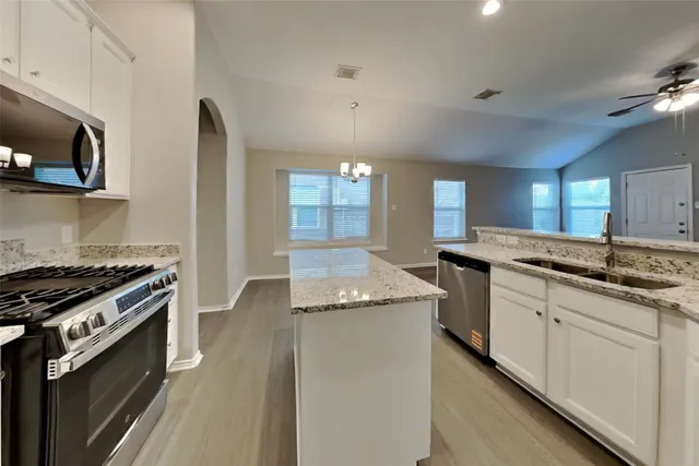 a kitchen with stainless steel appliances granite countertop a sink and a stove