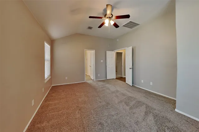 en empty room with ceiling fan and window