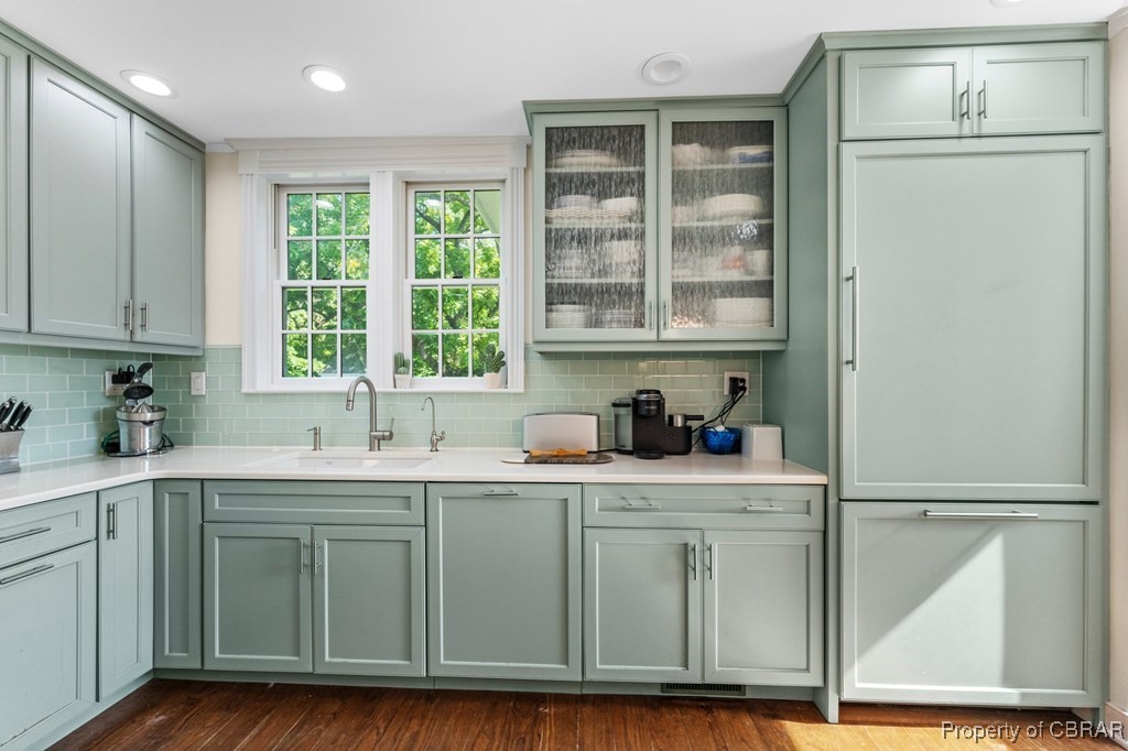 1701 Balls Neck Road Kilmarnock, VA 22482 - Photo 37 of 50 Kitchen featuring sink, green cabinets, wood-type flooring, and backsplash