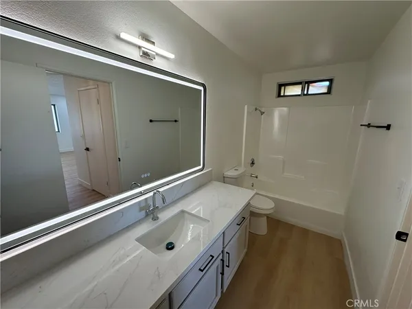 a bathroom with a tub sink and mirror