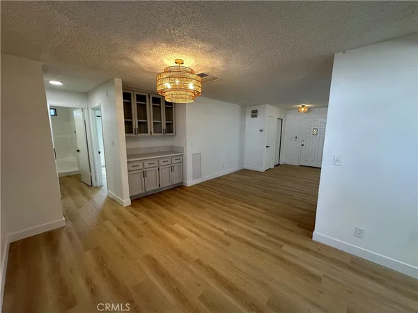 an empty room with wooden floor and cabinet