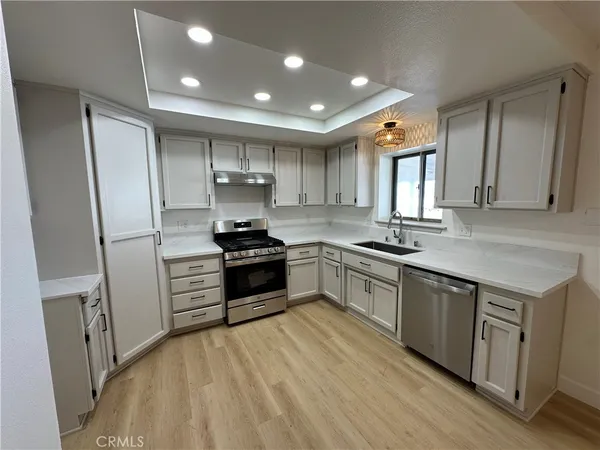 a kitchen with granite countertop a refrigerator stove top oven and sink