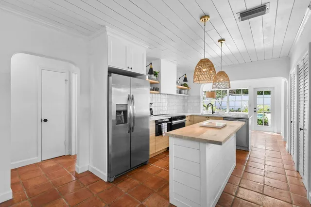 a kitchen with stainless steel appliances granite countertop a sink and a refrigerator