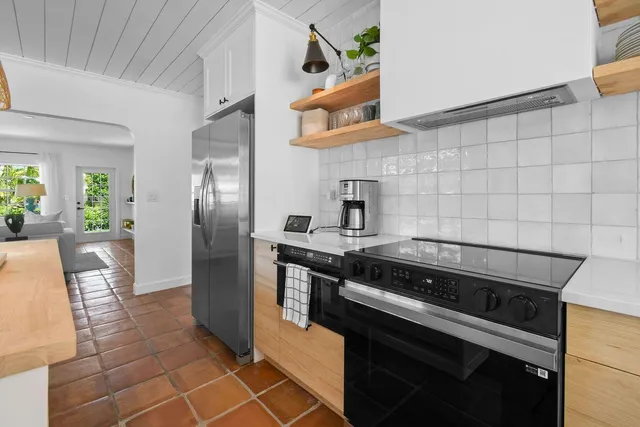 a kitchen with stainless steel appliances granite countertop a stove a refrigerator and a microwave